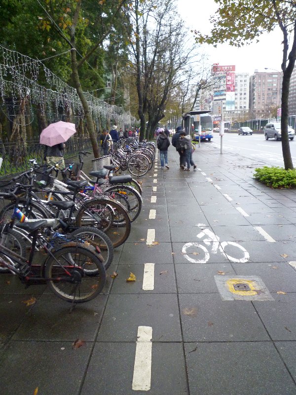 鬧巿街道旁的單車泊位及清楚標示出的單車通道，留意是和行人道並行而無需分隔。